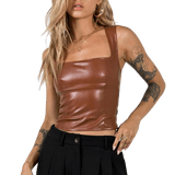Brun lädertopp. En blond tjej poserar med en synlig tatuering på armen.