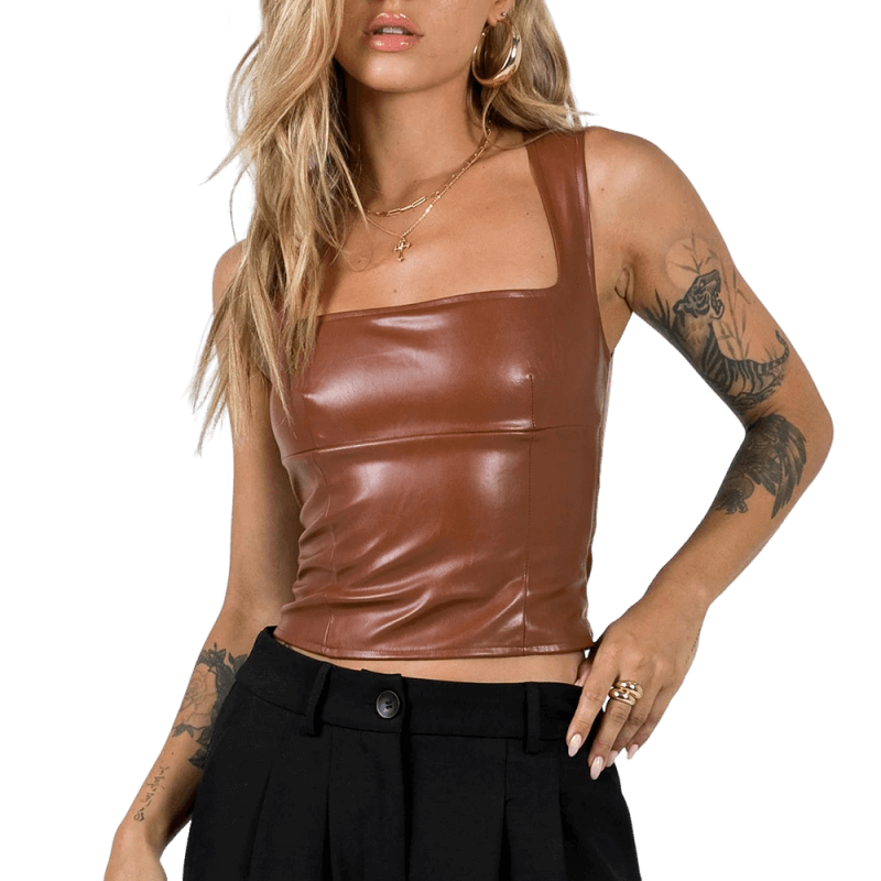 Brun lädertopp. En blond tjej poserar med en synlig tatuering på armen.